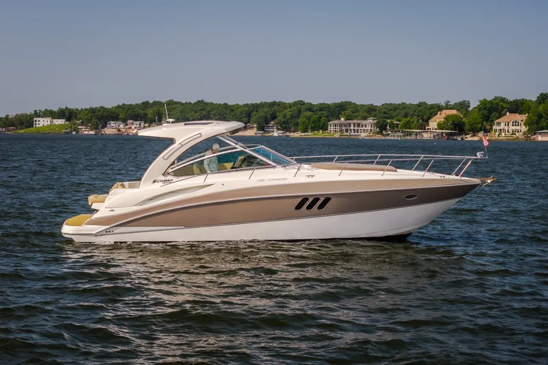 Slide: The Image of 2012 Cruisers Yachts 380 Express on a serene lake with waterfront homes in the background. - 7