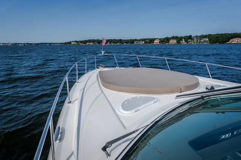 Slide: The Image of 2012 Cruisers Yachts 380 Express on calm water, scenic shoreline view. - 60