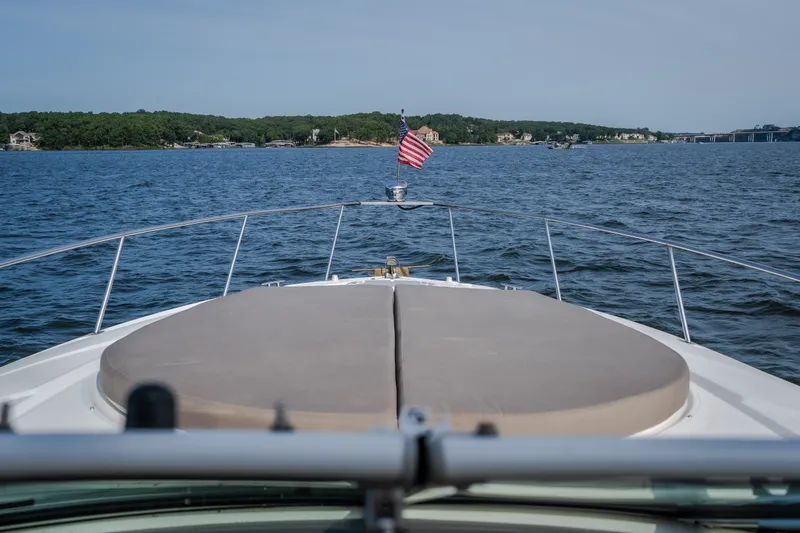 Slide: The Image of Bow view of 2012 Cruisers Yachts 380 Express on a serene lake with American flag. - 56