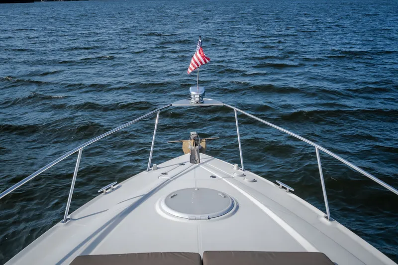 Slide: The Image of Bow view of 2012 Cruisers Yachts 380 Express on open water with American flag. - 58
