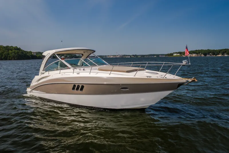Slide: The Image of 2012 Cruisers Yachts 380 Express on a serene lake under a clear blue sky. - 1