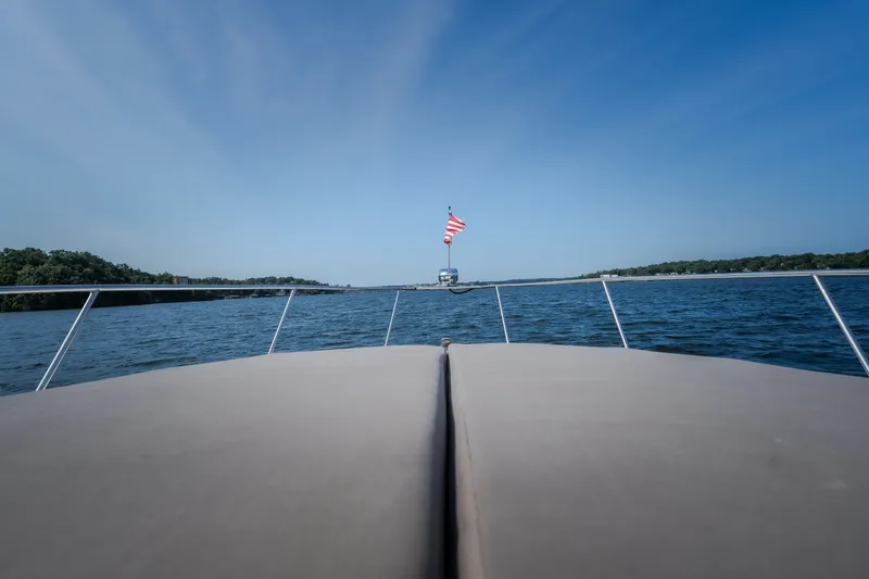 Slide: The Image of 2012 Cruisers Yachts 380 Express on open water with American flag, clear sky. - 59