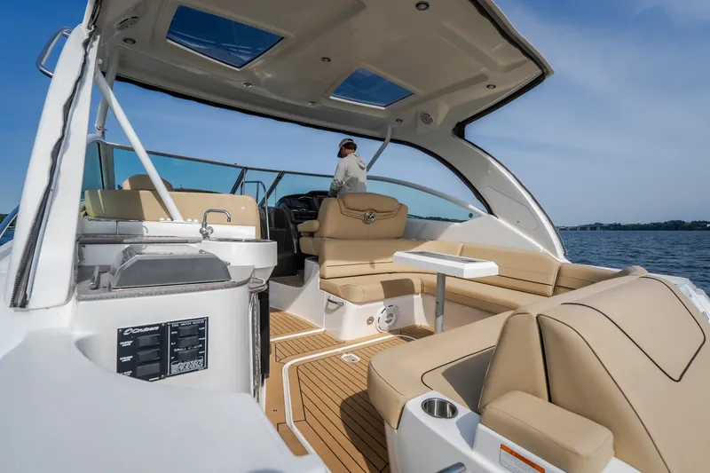 Slide: The Image of 2012 Cruisers Yachts 380 Express interior with beige seating and open water view. - 20