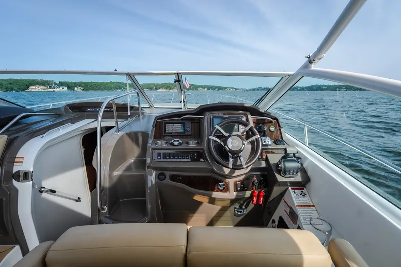 Slide: The Image of 2012 Cruisers Yachts 380 Express helm with modern controls, overlooking serene waters. - 34