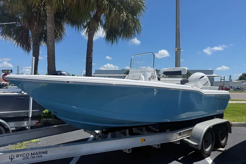 The Image of 2027 Tidewater 180 CC Adventure boat on trailer, parked under palm trees, clear blue sky. - 0