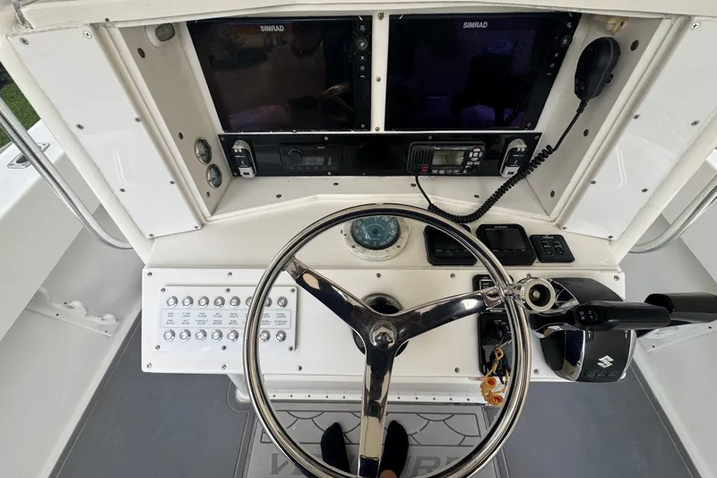 Slide: The Image of 1997 Venture 34 Center Console boat dashboard with steering wheel and navigation controls. - 23