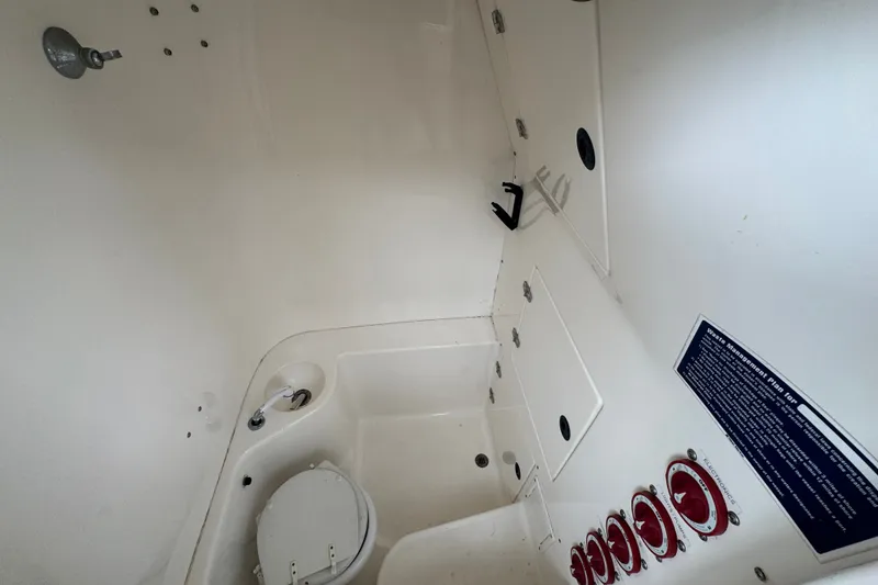 Slide: The Image of Interior of a 1997 Venture 34 Center Console boat, featuring a compact marine toilet. - 29