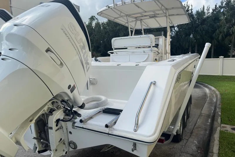 Slide: The Image of 1997 Venture 34 Center Console boat with Suzuki outboard motor, parked on a driveway. - 15