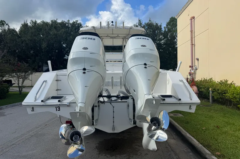Slide: The Image of 1997 Venture 34 Center Console boat with dual 300 horsepower engines, parked outdoors. - 14