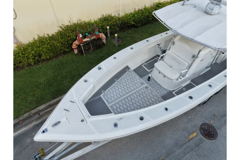 Slide: The Image of 1997 Venture 34 Center Console boat on trailer, parked near greenery. - 10