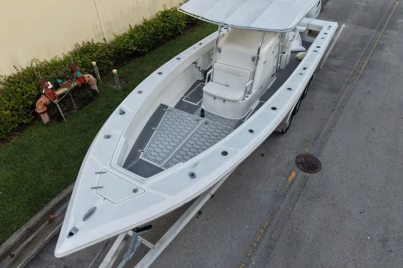 Slide: The Image of 1997 Venture 34 Center Console boat on trailer, viewed from above, parked near greenery. - 2