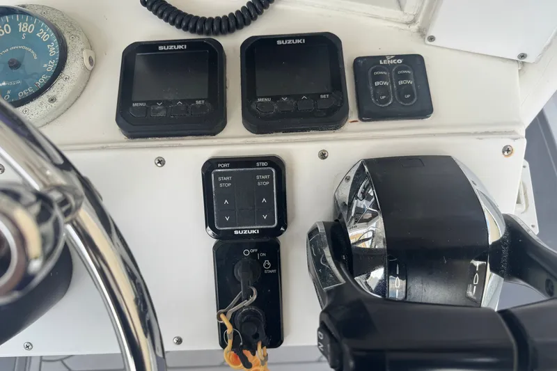 Slide: The Image of Control panel of a 1997 Venture 34 Center Console boat with Suzuki instruments. - 24