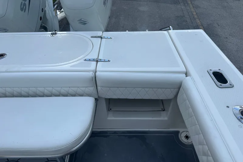 Slide: The Image of 1997 Venture 34 Center Console boat interior with white cushioned seating and storage compartments. - 33