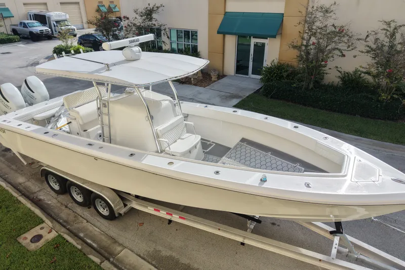 Slide: The Image of 1997 Venture 34 Center Console boat on trailer, parked outside a building. - 1