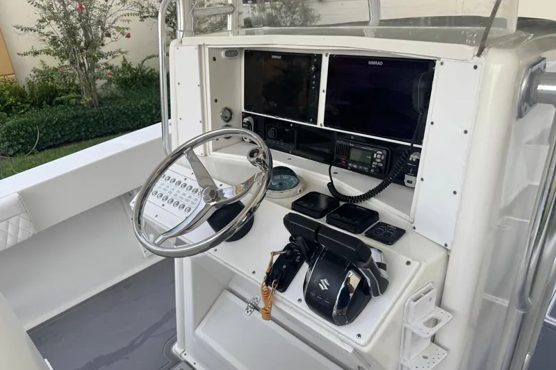 Slide: The Image of 1997 Venture 34 Center Console boat dashboard with steering wheel and navigation controls. - 21