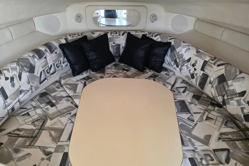 Slide: The Image of Interior of 1997 Sea Ray 250 Sundancer with patterned seating and black cushions. - 12