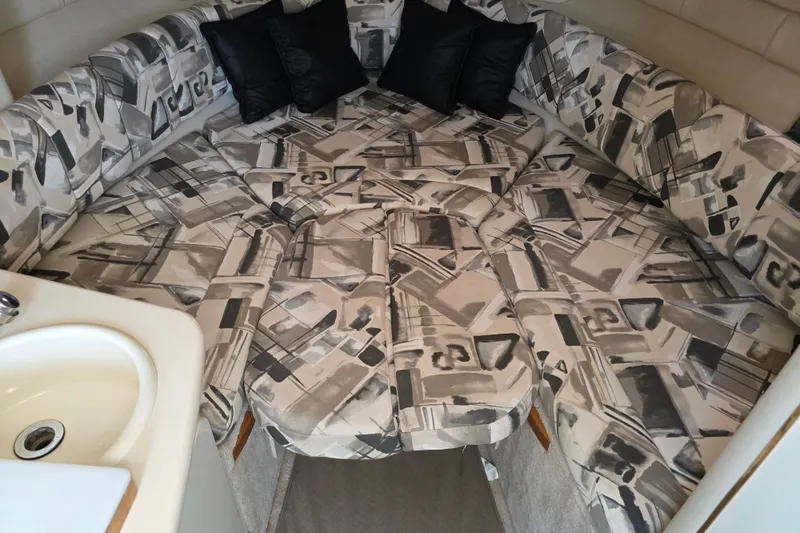Slide: The Image of 1997 Sea Ray 250 Sundancer cabin interior with patterned seating and sink. - 13