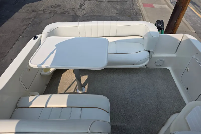 Slide: The Image of 1997 Sea Ray 250 Sundancer boat interior with white seating and table setup. - 6
