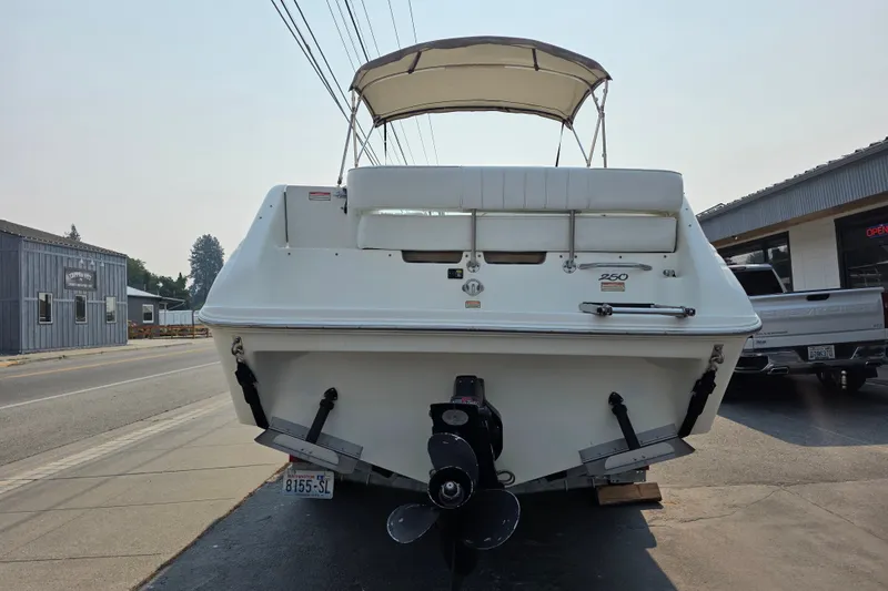 Slide: The Image of 1997 Sea Ray 250 Sundancer boat parked on a street, rear view. - 4