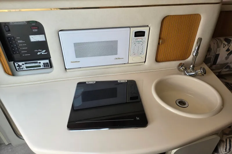 Slide: The Image of 1997 Sea Ray 250 Sundancer cabin with microwave, sink, and control panel. - 17