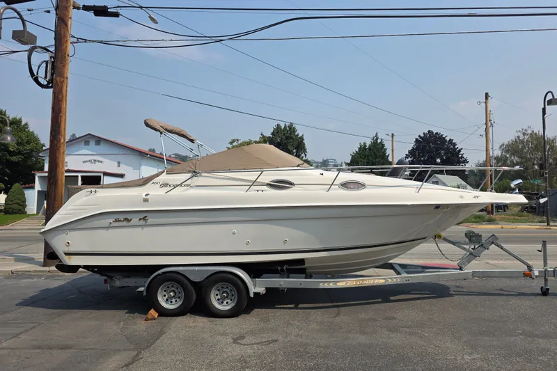 Slide: The Image of 1997 Sea Ray 250 Sundancer boat on trailer, parked outdoors. - 1
