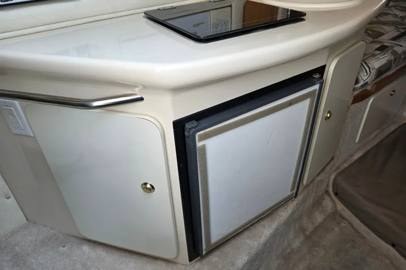 Slide: The Image of Interior of a 1997 Sea Ray 250 Sundancer boat with kitchenette and storage. - 19