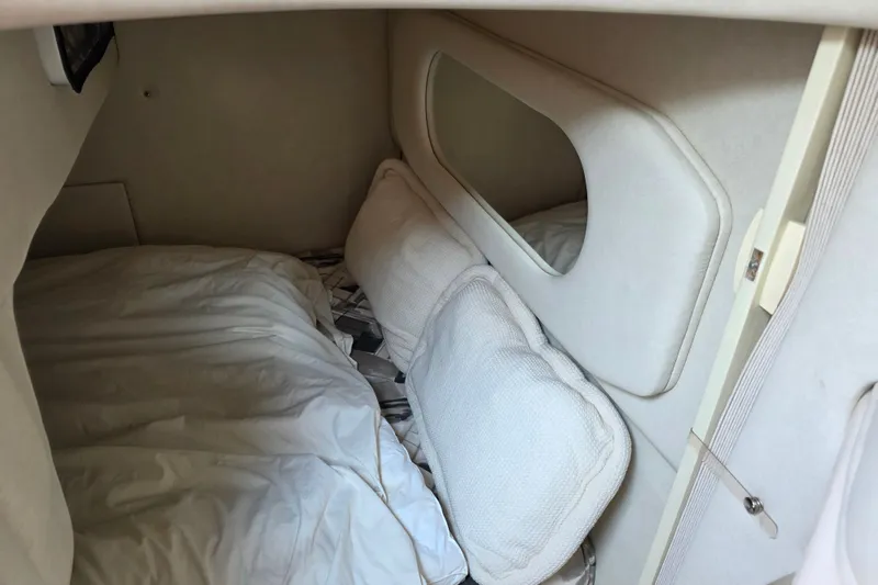 Slide: The Image of Cozy cabin interior of a 1997 Sea Ray 250 Sundancer boat with bedding and pillows. - 21