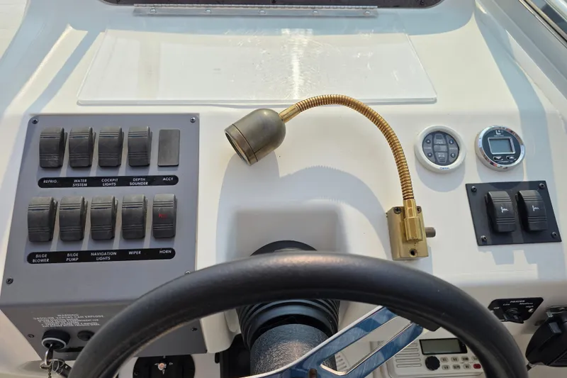 Slide: The Image of 1997 Sea Ray 250 Sundancer dashboard with controls, switches, and steering wheel. - 10