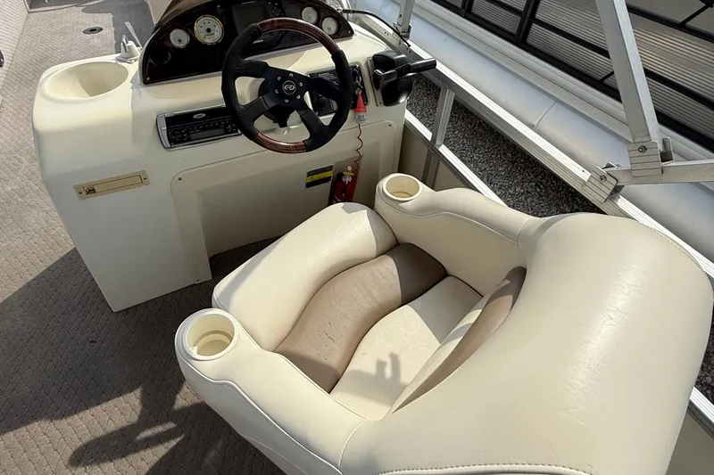 Slide: The Image of 2005 Avalon Paradise Elite 2425 boat helm with beige captain's chair and steering wheel. - 9