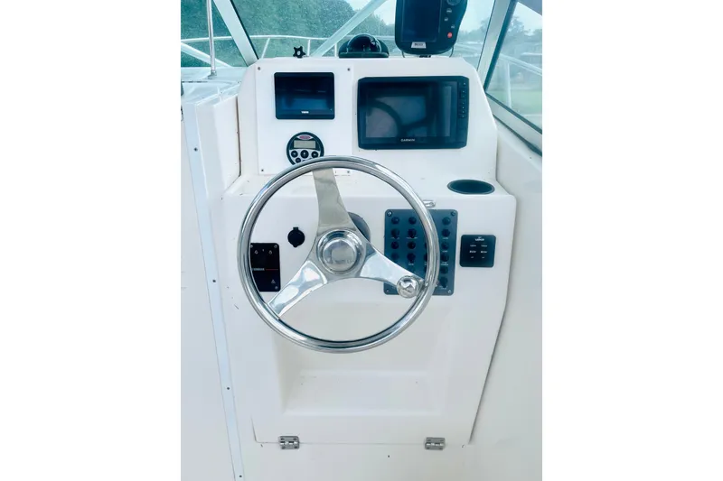 Slide: The Image of Helm of 2004 Robalo R235 Walkaround boat with steering wheel and navigation equipment. - 5