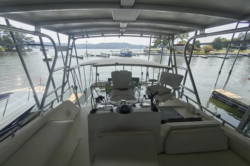 Slide: The Image of The image shows the cockpit of a 1979 Viking 42 boat docked on a calm lake. - 12