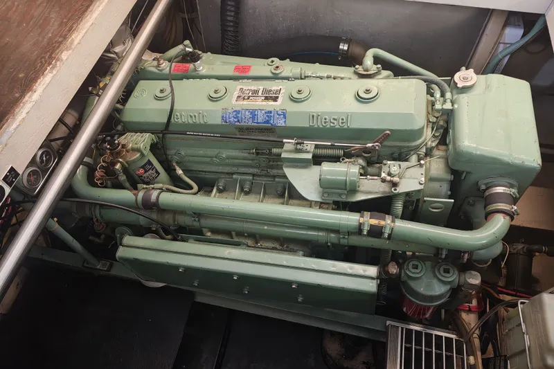 Slide: The Image of A green marine diesel engine in an engine room, surrounded by pipes and gauges. - 19