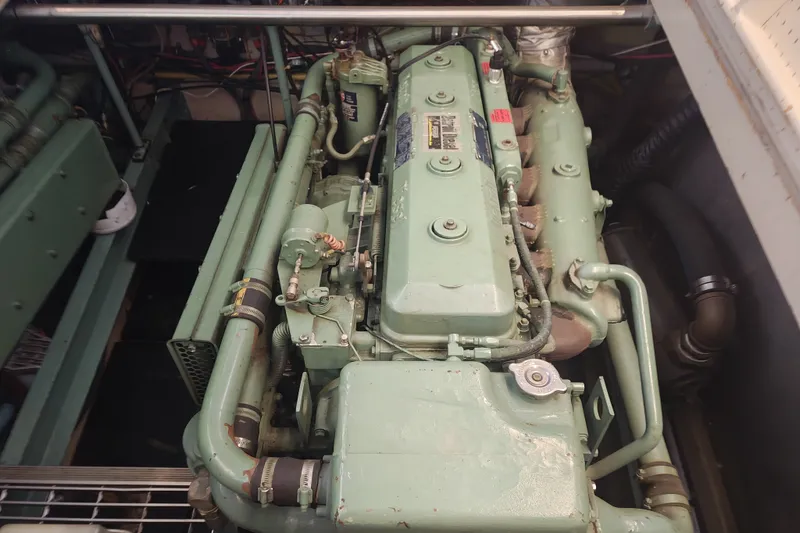 Slide: The Image of A green engine in a boat's engine room with pipes and cables. - 18