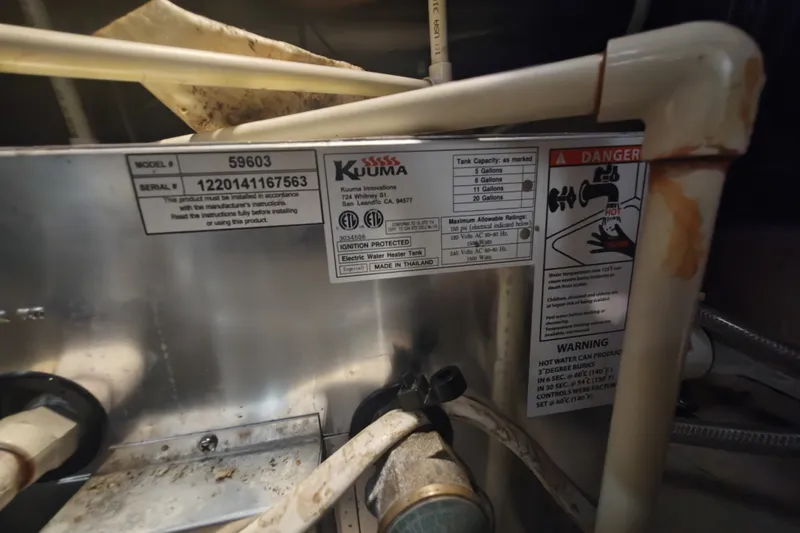 Slide: The Image of Close-up of a Kuuma water heater with warning labels and technical details. - 30