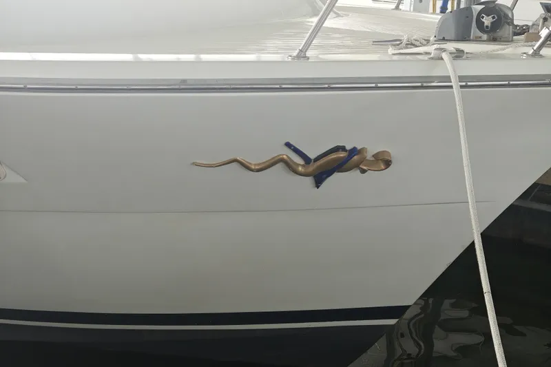Slide: The Image of Side view of a white boat with a gold snake detail. - 3