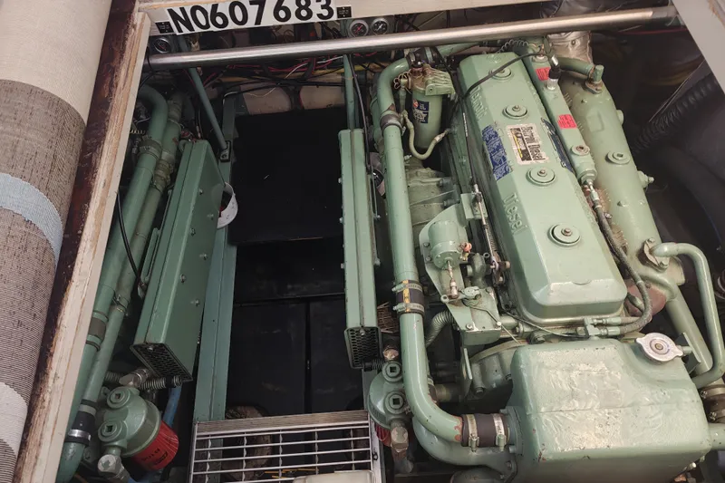 Slide: The Image of The engine room of a 1979 Viking 42 with a large green engine and various pipes and cables. - 20