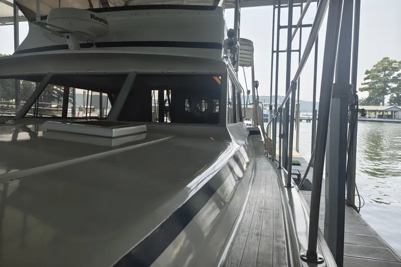 Slide: The Image of A 1979 Viking 42 boat docked. It features a covered upper deck. - 1