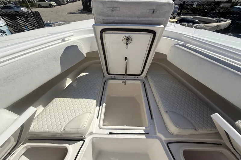 Slide: The Image of 2019 HCB 42 Siesta boat interior with open storage compartments and cushioned seating. - 30
