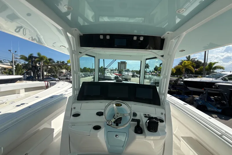 Slide: The Image of 2019 HCB 42 Siesta boat helm with modern controls and panoramic marina view. - 19