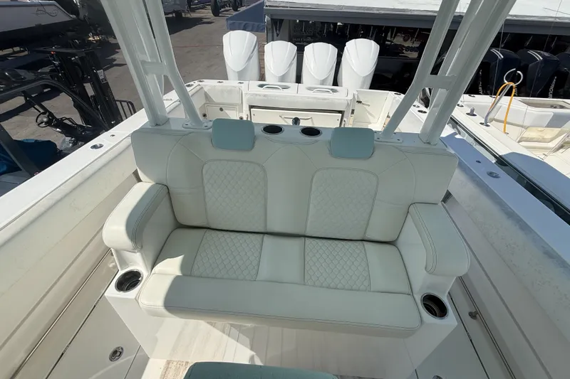 Slide: The Image of 2019 HCB 42 Siesta boat interior with white cushioned seating and cup holders. - 24