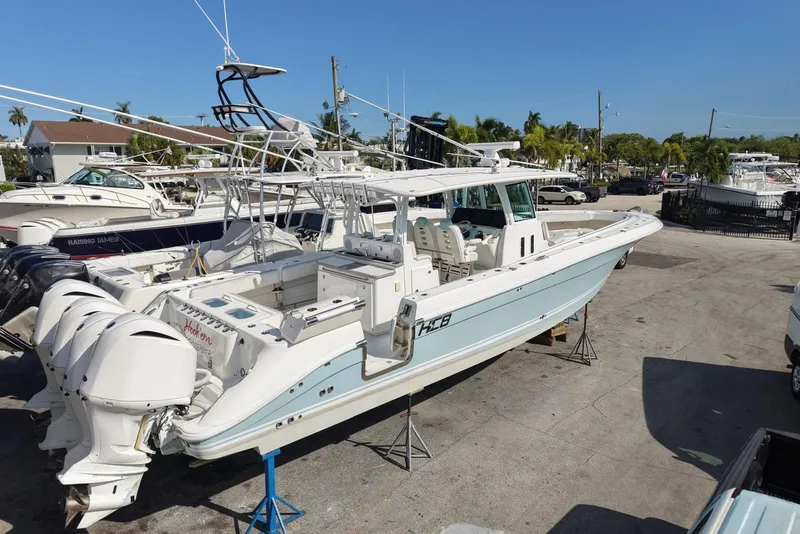 Slide: The Image of 2019 HCB 42 Siesta boat with multiple outboard engines, docked in a marina under clear blue skies. - 1
