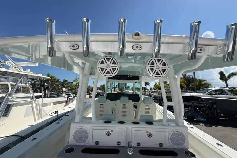 Slide: The Image of 2019 HCB 42 Siesta boat interior with rod holders and speakers under a clear blue sky. - 10