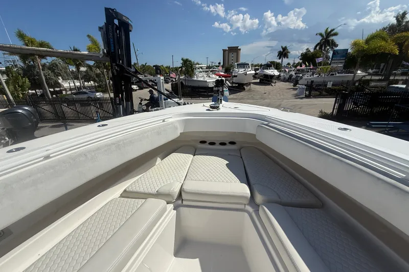 Slide: The Image of 2019 HCB 42 Siesta boat interior with cushioned seating, docked at a marina under a sunny sky. - 27