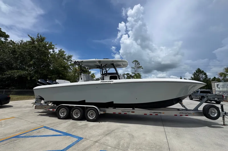 Slide: The Image of 2024 Fountain 34 Tournament Edition boat on trailer under cloudy sky. - 11