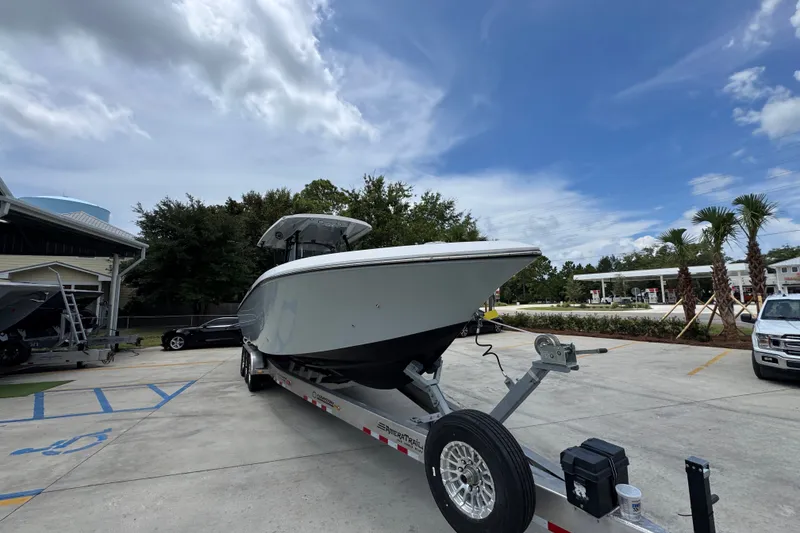 Slide: The Image of 2024 Fountain 34 Tournament Edition boat on trailer, parked outdoors under a cloudy sky. - 8