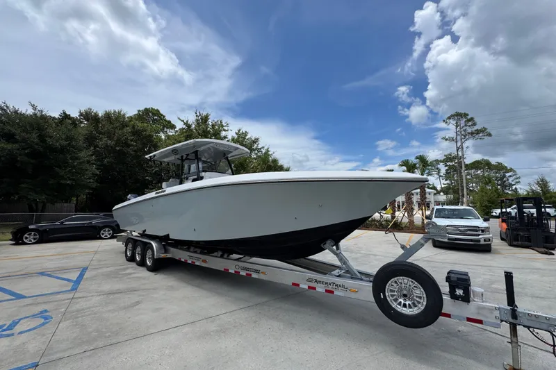 Slide: The Image of 2024 Fountain 34 Tournament Edition boat on trailer, parked outdoors under a partly cloudy sky. - 9