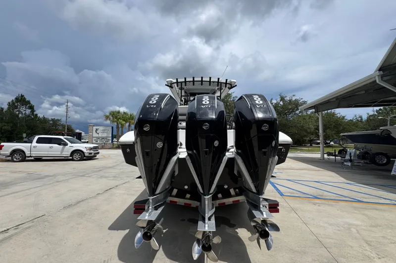 Slide: The Image of 2024 Fountain 34 Tournament Edition boat with triple outboard engines in a parking lot. - 17