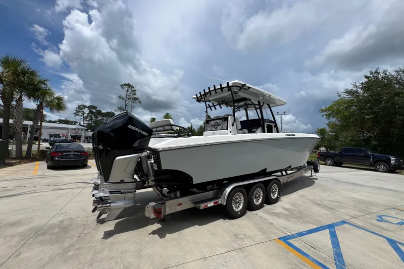 Slide: The Image of 2024 Fountain 34 Tournament Edition boat on trailer, parked outdoors under cloudy sky. - 14