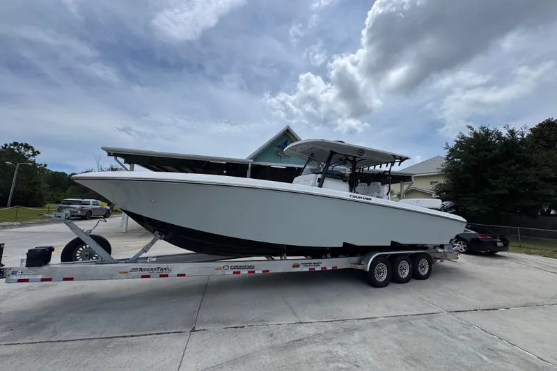 Slide: The Image of 2024 Fountain 34 Tournament Edition boat on trailer, parked outdoors under cloudy sky. - 3
