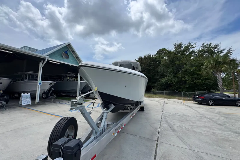Slide: The Image of 2024 Fountain 34 Tournament Edition boat on trailer at dealership, under cloudy sky. - 6